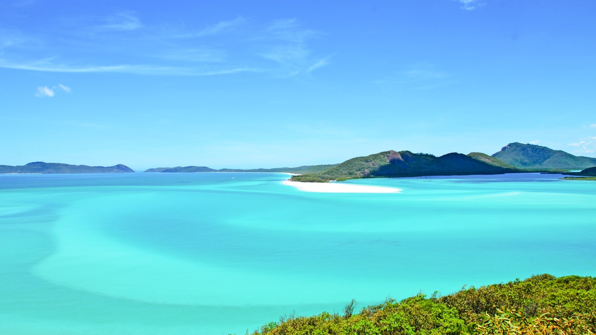 Clear turquoise water and lush islands of The Whitsundays, Australia.