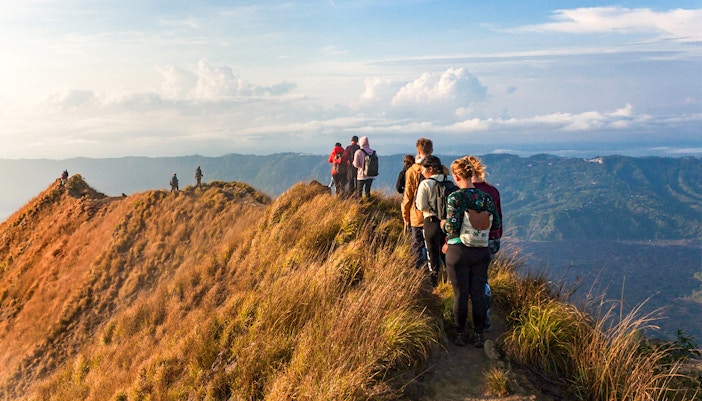 Group of people trekking Mount Batur during sunrise