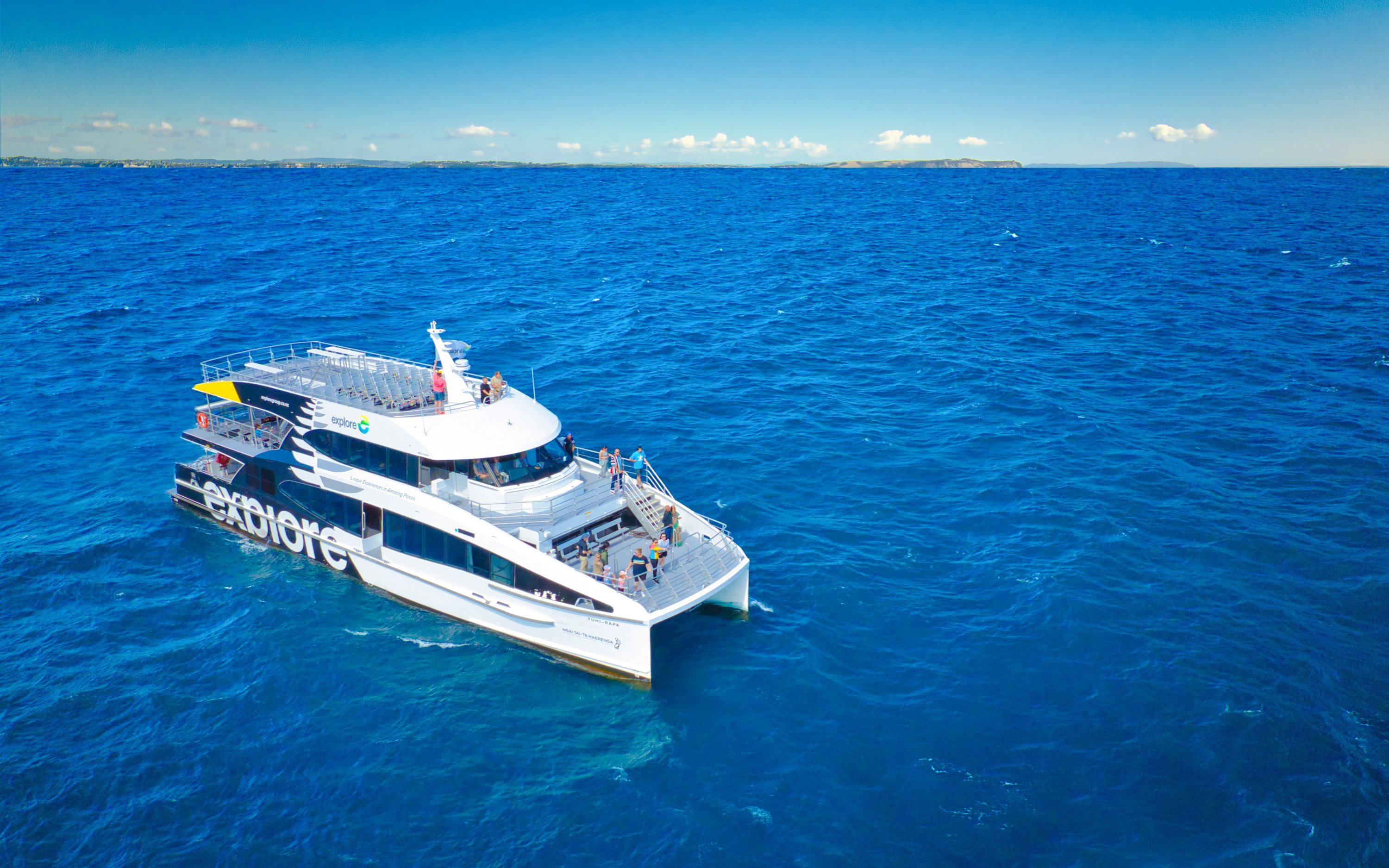 Cruise ship on Auckland's Tikapa Moana, passengers enjoying ocean views.