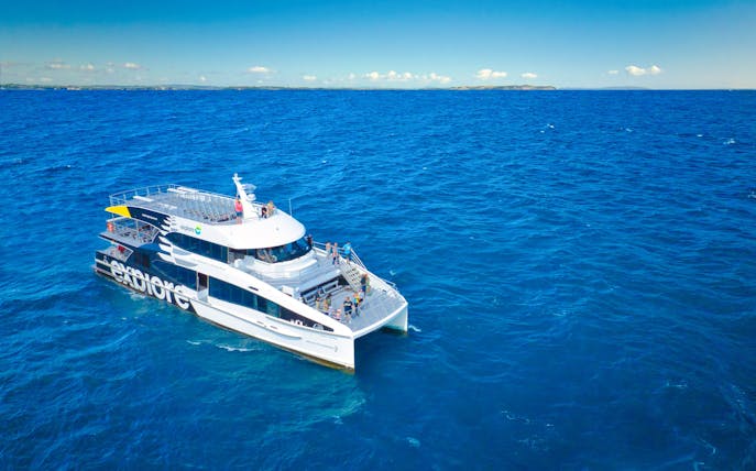Cruise ship on Auckland's Tikapa Moana, passengers enjoying ocean views.
