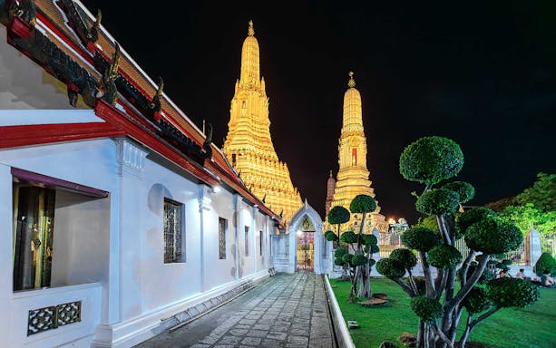 Wat Arun illuminated at night during a Bangkok night bike tour.