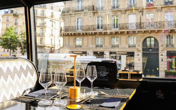 Interior dining setup of Bus Toqué Paris with view of Parisian street through window.