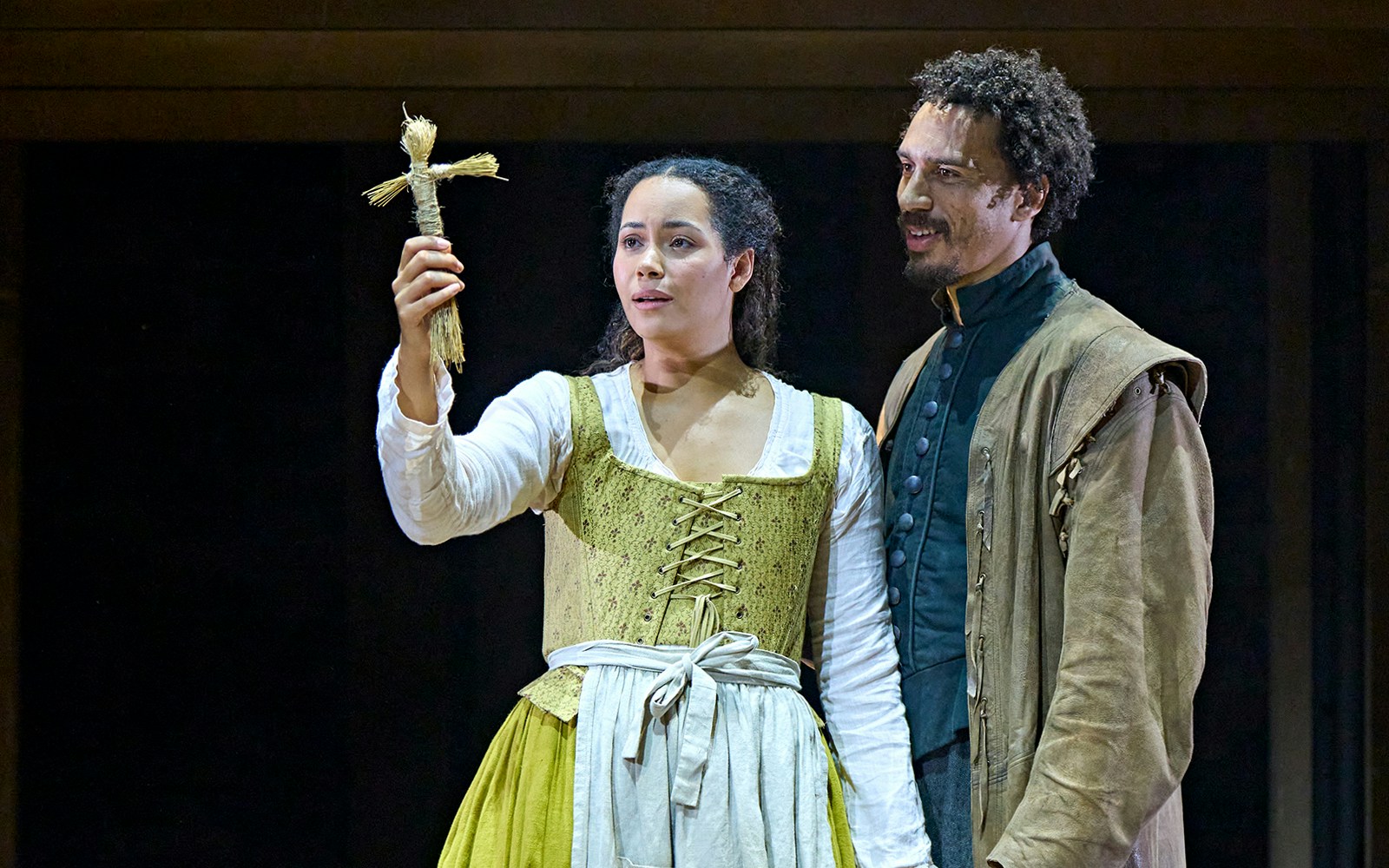 Actors on stage holding a straw doll in a scene from "Hamnet.