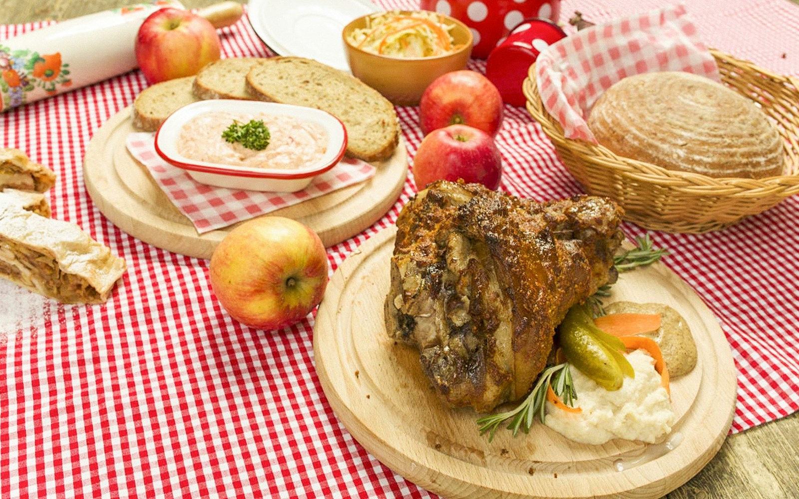 Folklore performers in traditional attire with meat dishes at Prague dinner show.
