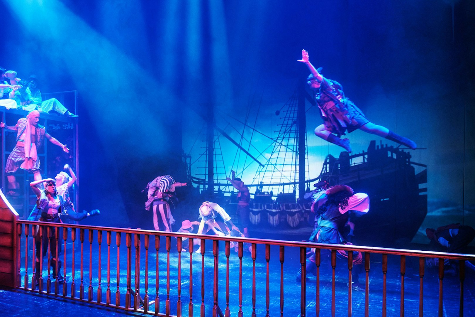 Stage performance of "Peter, El Musical" with actors in pirate costumes and ship backdrop.