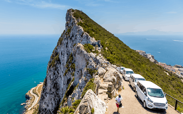 Gibraltar Rock view with tour vans and ocean backdrop on a full-day tour from Málaga.