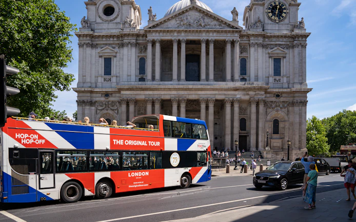 Open-top Tootbus passing St. Paul's Cathedral in London.