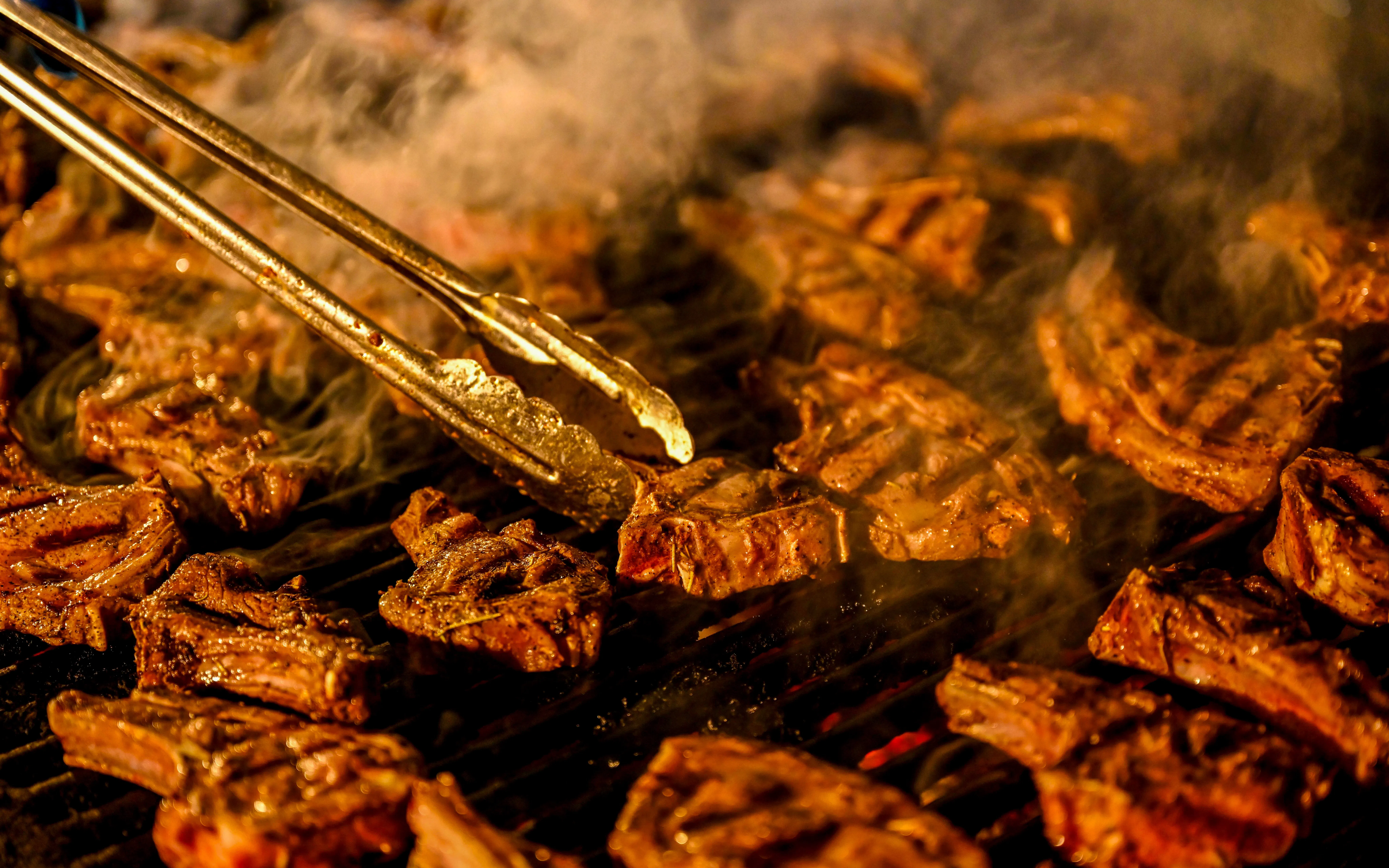BBQ lamb chops grilling during desert safari experience.