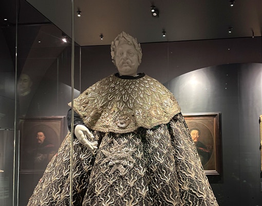 Textile display with ornate robe and mannequin at Wawel Castle.
