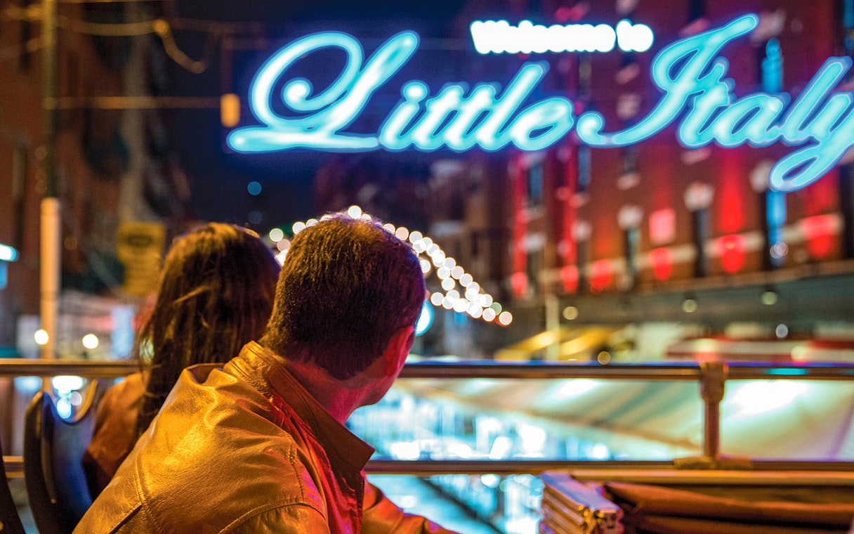 Couple on a bus tour viewing holiday lights in Little Italy at night.
