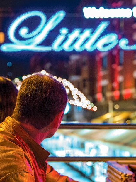 Couple on a bus tour viewing holiday lights in Little Italy at night.