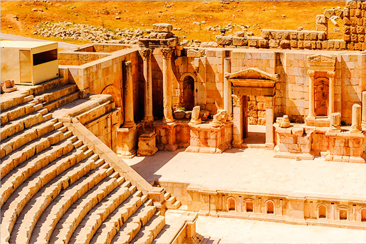 Roman amphitheater ruins in Jerash, Jordan, with stone columns and seating.