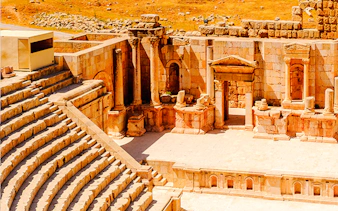 Roman amphitheater ruins in Jerash, Jordan, with stone columns and seating.