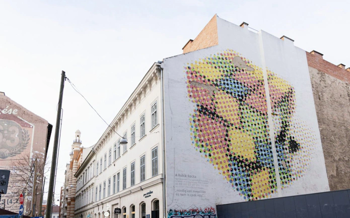 Street art mural on a building in Budapest's Jewish Quarter during guided tour.