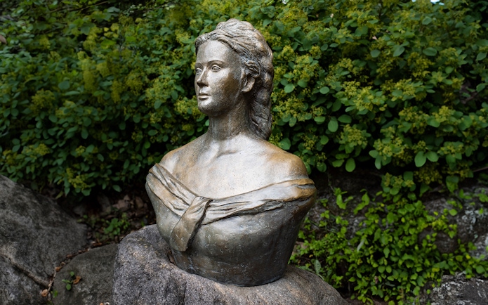 Bust of Empress Elisabeth of Austria-Hungary in a garden setting.