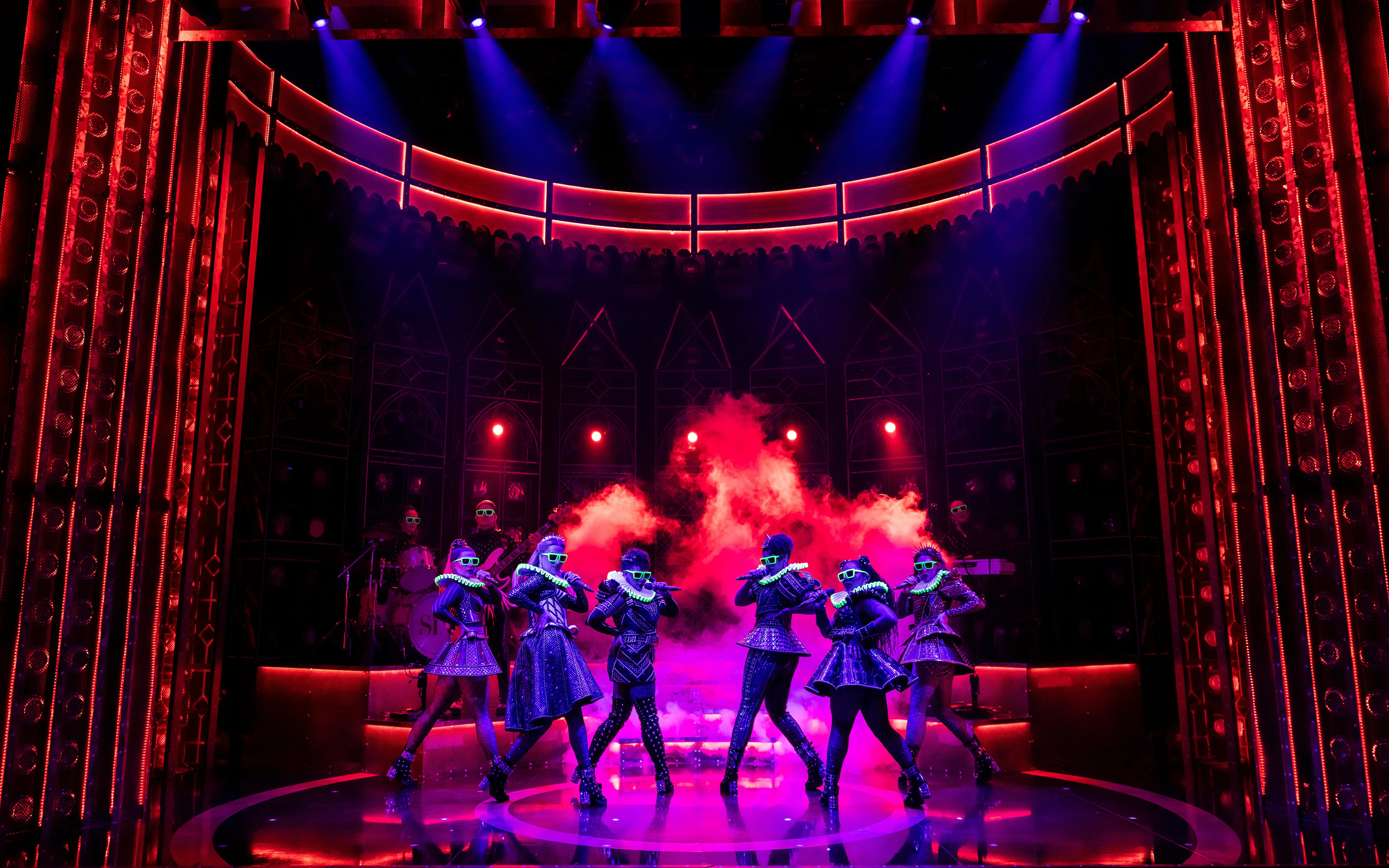 Performance of Six musical at West End with vibrant lighting and costumes.
