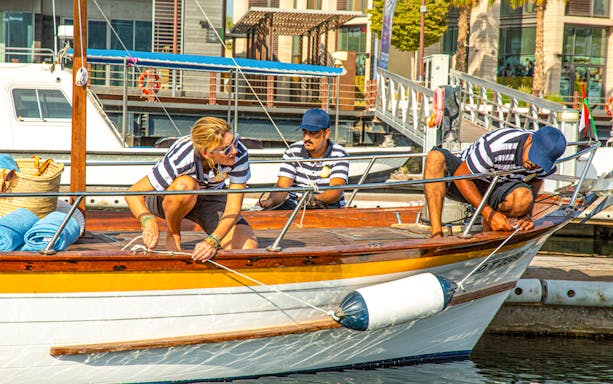 Crew preparing traditional boat for Dubai historical tour.