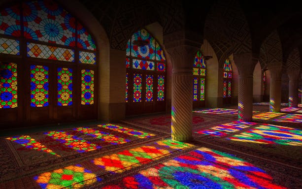 Stained glass windows casting colorful patterns inside Museu do Vitral, Porto.