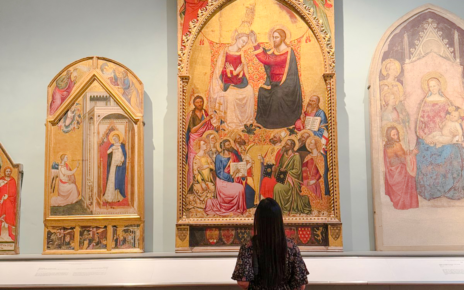 Coronation of the Virgin painting in Accademia Gallery, Florence, viewed by a visitor.