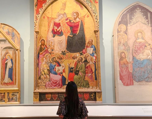 Coronation of the Virgin painting in Accademia Gallery, Florence, viewed by a visitor.
