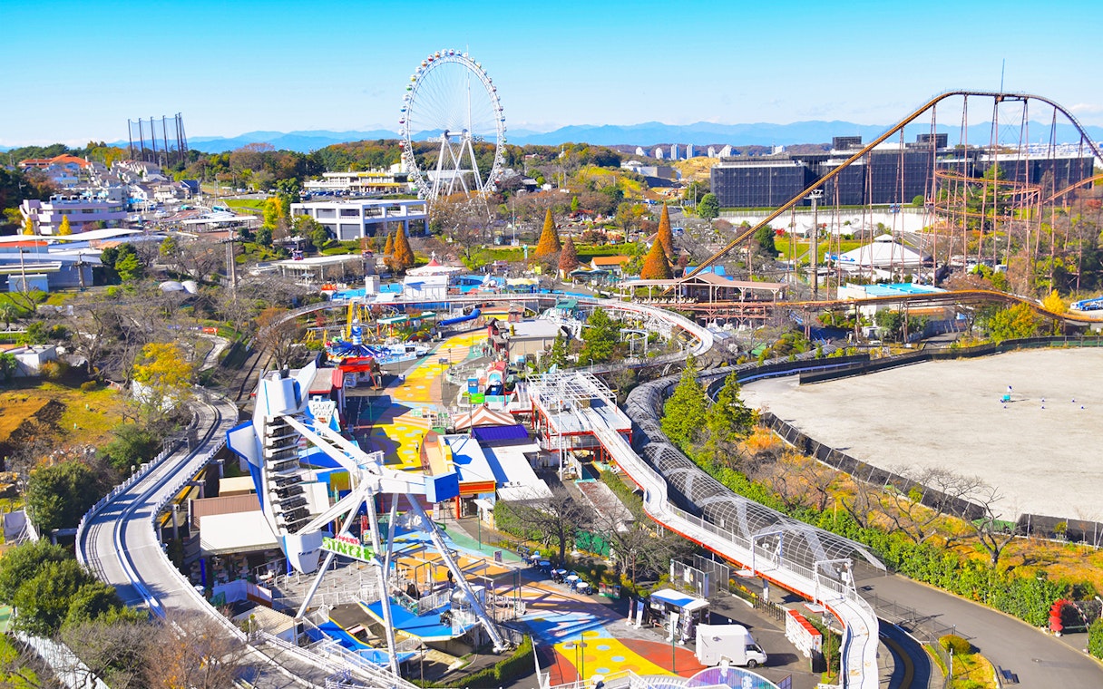 Yomiuriland amusement park with roller coasters and Ferris wheel in Tokyo, Japan.