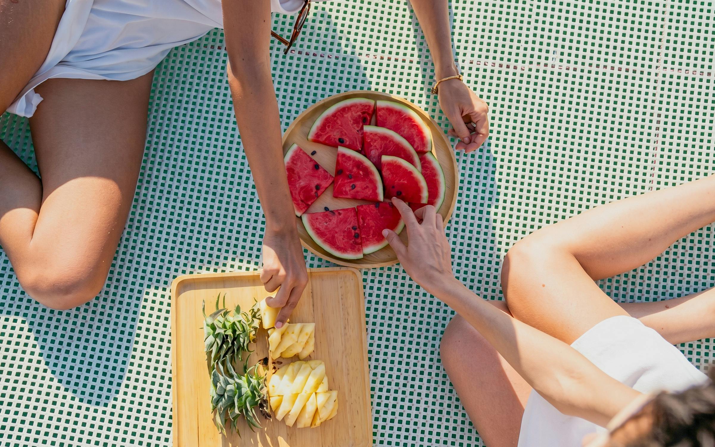 Guests enjoying fresh watermelon and pineapple on Heraklion catamaran cruise.