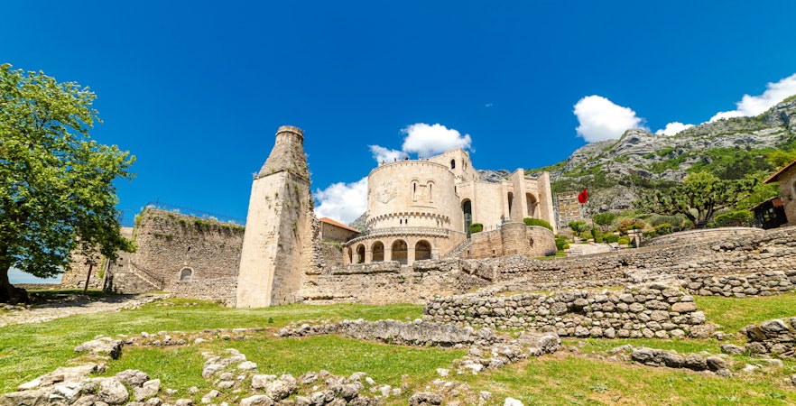 Kruja Castle in Albania with stone walls and mountainous backdrop.