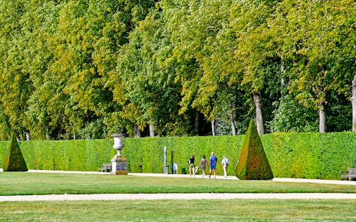 Visitors walking through the gardens of Château of Vaux-le-Vicomte, France.