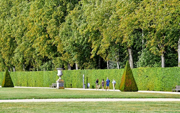 Visitors walking through the gardens of Château of Vaux-le-Vicomte, France.