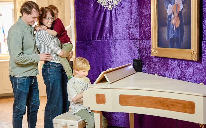 Guests enjoying interactive exhibits at Mozart Museum in Prague.