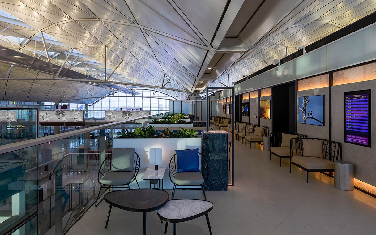 Plaza Premium Lounge seating area with modern decor and flight information display.