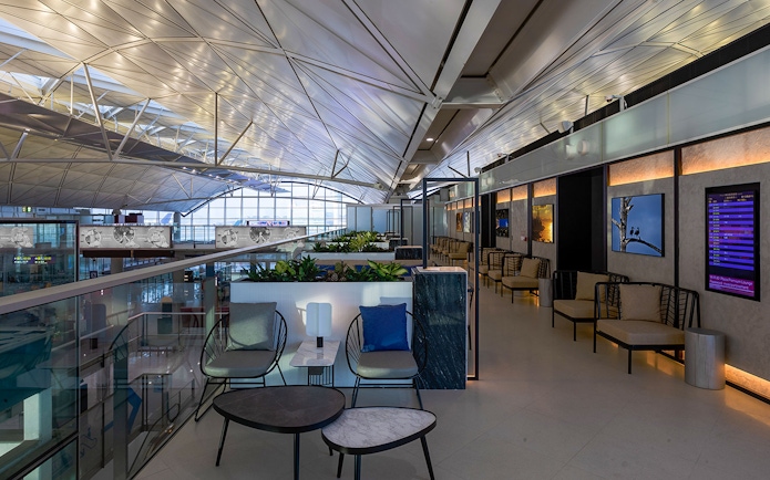 Plaza Premium Lounge seating area with modern decor and flight information display.