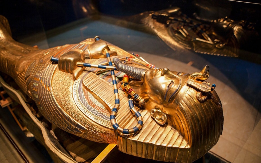 Golden sarcophagus of an Egyptian pharaoh displayed at the Grand Egyptian Museum.
