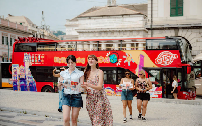 Tourists with maps near a Genova city sightseeing bus.