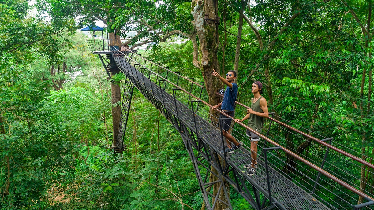 Homens praticando tirolesa em uma floresta exuberante no Hanuman World, em Phuket.