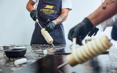 Participants shaping dough at a Chimney Cake Workshop in Budapest.