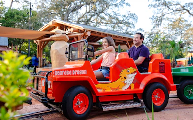 Child and adult riding Bearded Dragon jeep at ZooTampa, Tampa, Florida.
