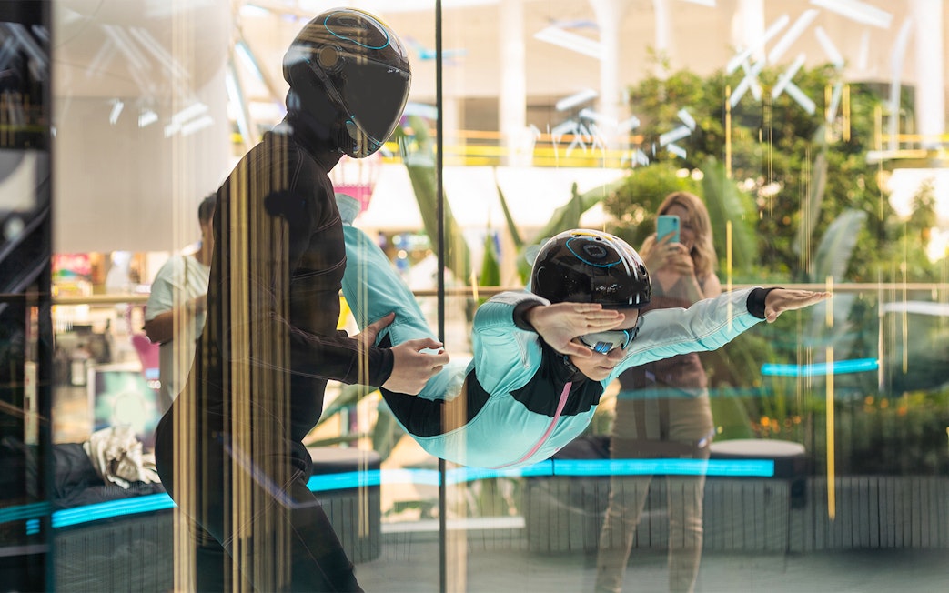 Young girl with instructor in iFly Dubai indoor skydive experience.