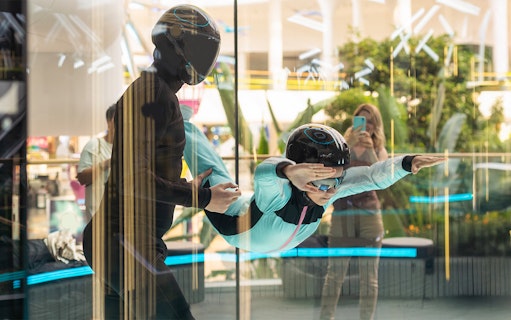 Young girl with instructor in iFly Dubai indoor skydive experience.
