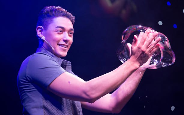 Performer creating large bubble at The Gazillion Bubble Show.