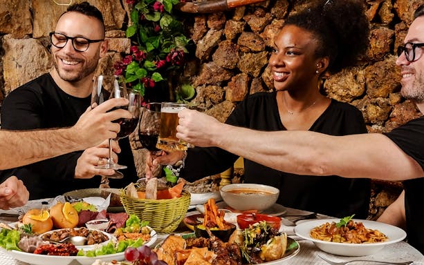 Guests toasting at a Folklore Dinner Show in a traditional Maltese restaurant.