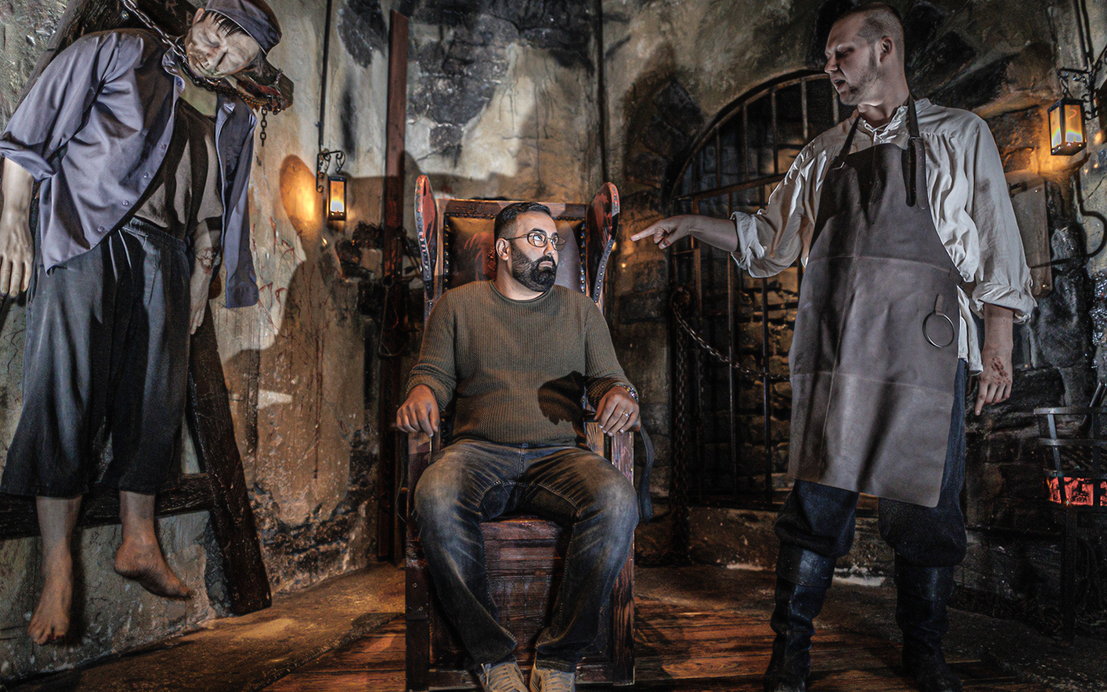 Torturer scene with actor and visitor inside Hamburg Dungeon.