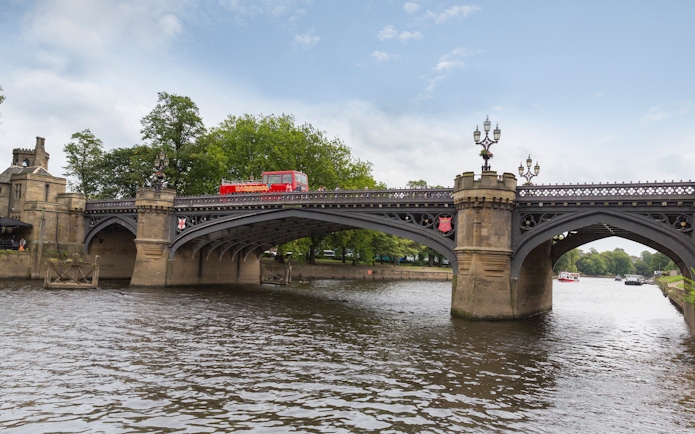 Red double-decker bus on Lendal Bridge during York Hop-On-Hop-Off Tour, England.