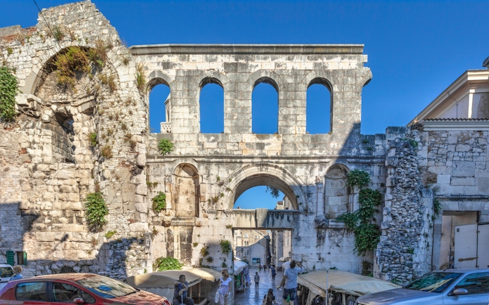 Silver Gate at Diocletian's Palace in Split with tourists exploring the ancient stone structure.