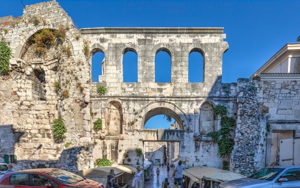Silver Gate at Diocletian's Palace in Split with tourists exploring the ancient stone structure.