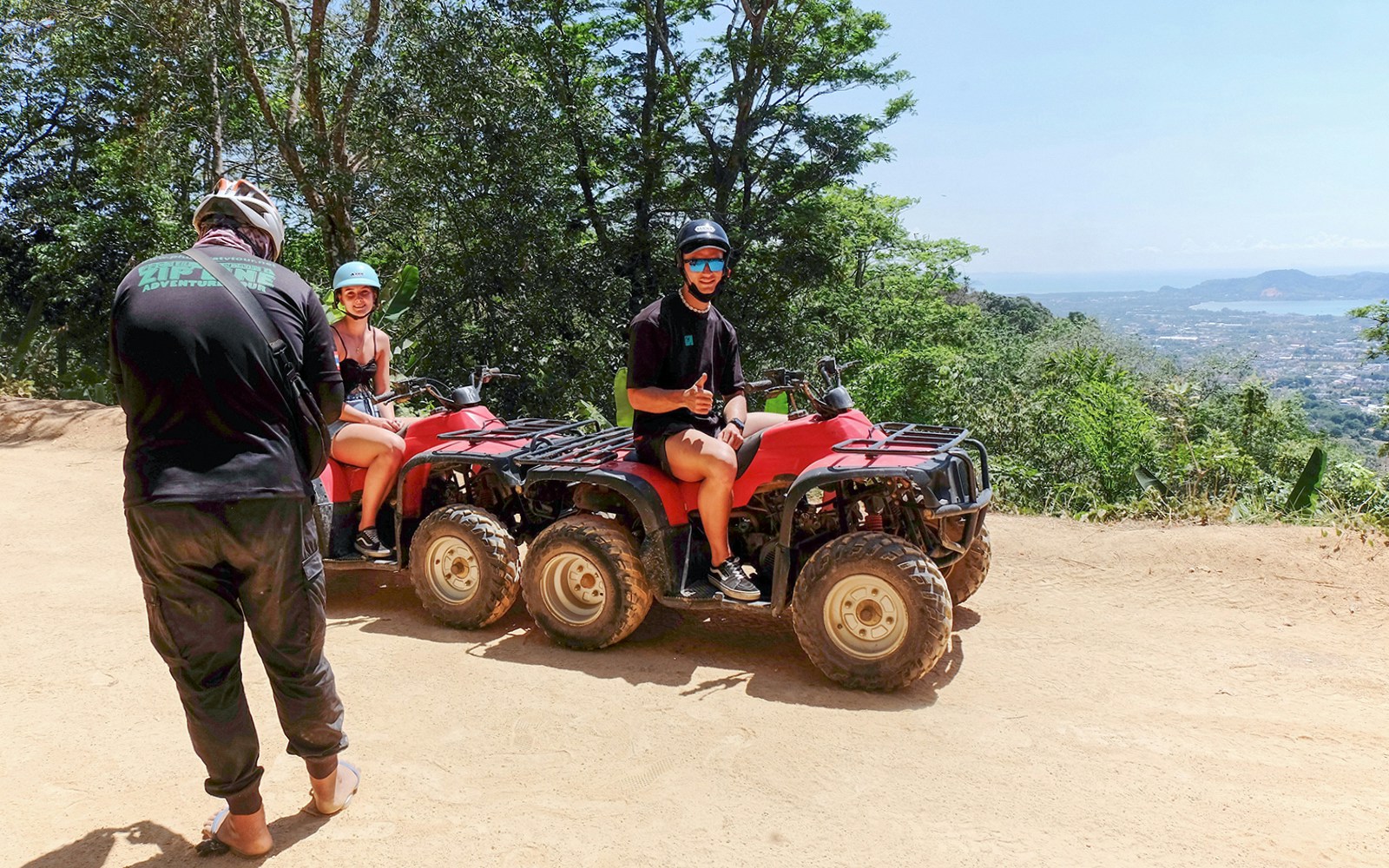 People posing for pictures on their ATVs with Phuket Sea in the distance, Phuket ATV Adventure tour