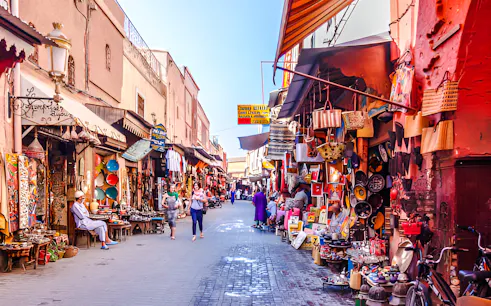 Bustling souk in Marrakesh with colorful shops and people exploring the market.