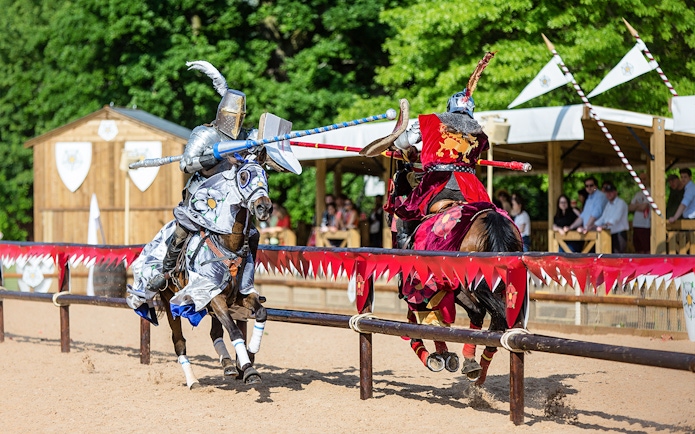 Jousting knights on horseback at Warwick Castle event.