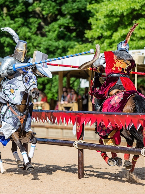 Jousting knights on horseback at Warwick Castle event.