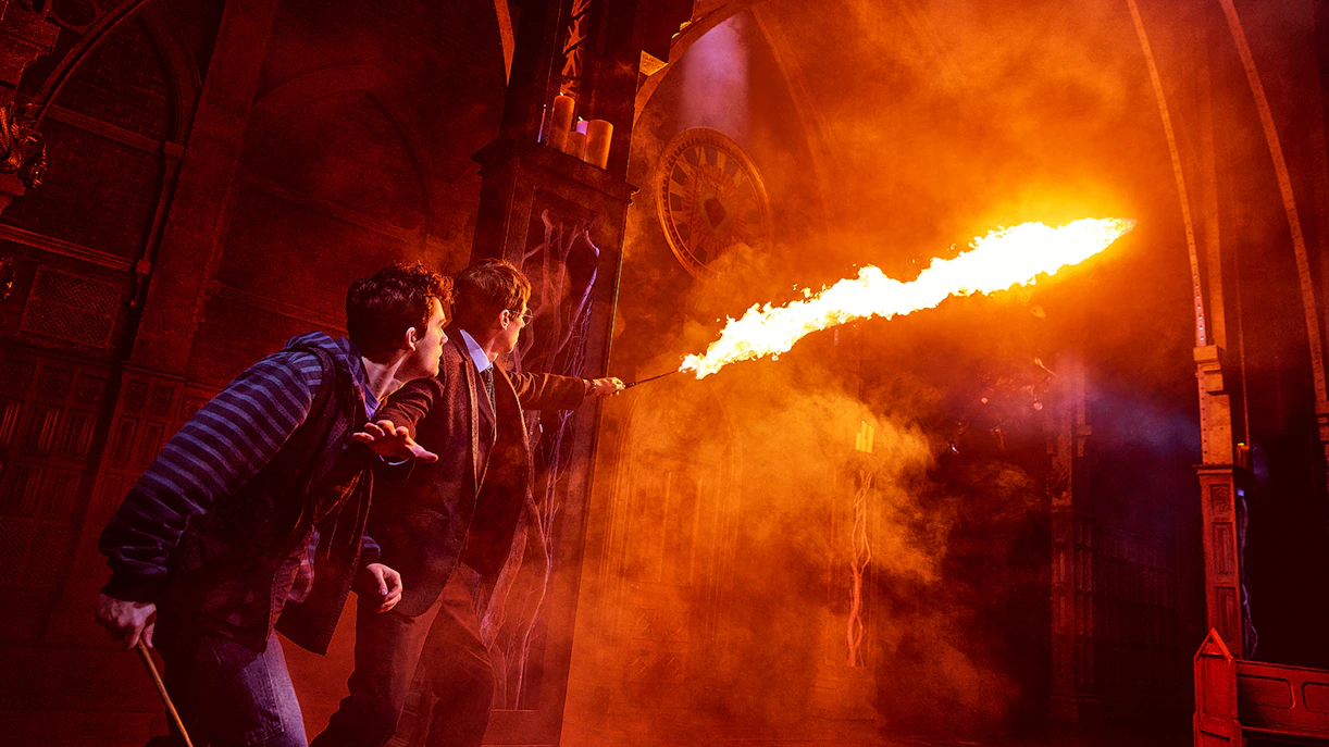 Characters casting a spell with fire in "Harry Potter and the Cursed Child" stage scene.